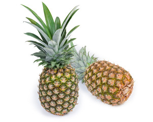 Two whole fresh pineapples on a white background