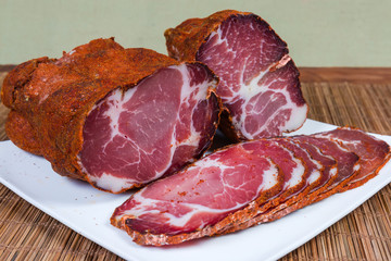 Partly sliced dried pork neck on dish close-up