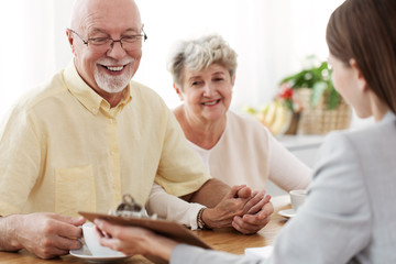 Smiling married couple talking to an estate agent