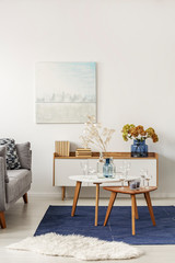 Light blue and grey abstract painting on empty white wall of stylish living room