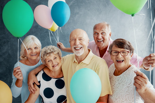 Happy senior people with colorful balloons during friends party