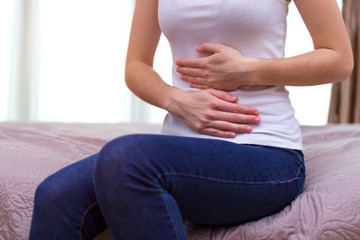 Young woman feels bad and experiences abdominal pain during the period of PMS and menstruation. Painful menstruation. Inflammation and Bladder Infection