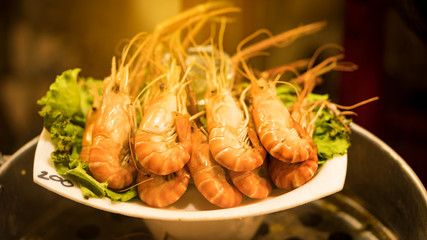 Grilled shrimp in a white plate, blurred background
