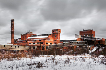 Fototapeta premium Old ruined factory construction in winter time. Urban exploration photography