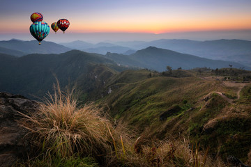 Hot air balloon flying over the peak of mountain and cloudscape at Phu chi fa in Chiangrai,Northen...