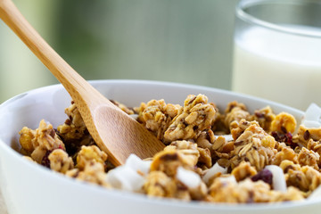 Dry breakfast cereals. Crunchy honey granola bowl with flax seeds, cranberries, coconut and a glass...