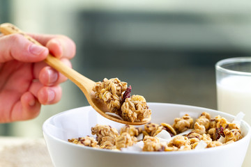 Dry breakfast cereals. Crunchy honey granola bowl with flax seeds, cranberries, coconut and a glass...
