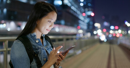Woman use of mobile phone in city at night