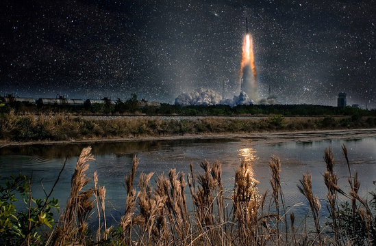 Missile launch at night. Tranquil nature landscape and reflection in the creek. The elements of this image furnished by NASA.