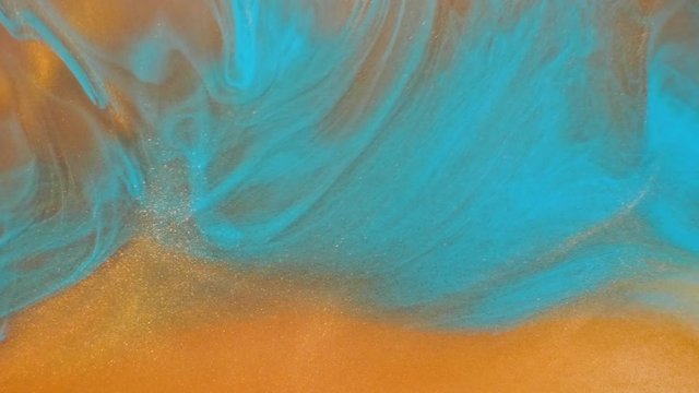 Colorful golden sand organically moves in colorful liquid