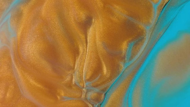 Colorful golden sand organically moves in colorful liquid