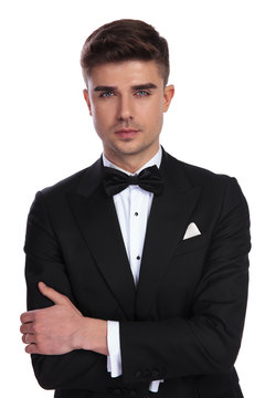 portrait of confident young groom in black tuxedo