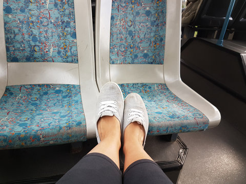 F&uuml;&szlig;e auf dem Sitz im Bus