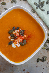 Home made pumpkin cream soup decorated with cream, seeds