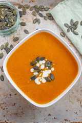 Home made pumpkin cream soup decorated with cream, seeds