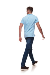 young man in polo shirt walks and looks to side