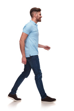 Side View Of Casual Man In Blue Polo Shirt Walking