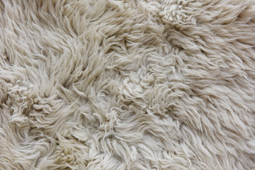 white grey fabric made of faux fur with long nap used for clothing and furniture and bedspreads	