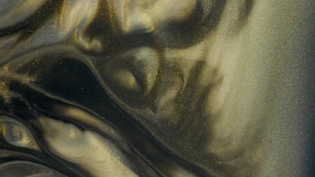 Colorful golden sand organically moves in colorful liquid