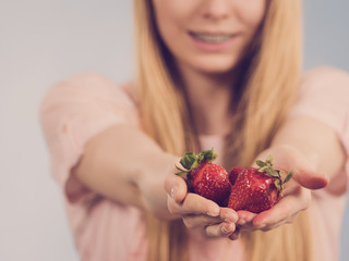 Girl showing fresh strawberries