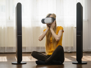 Girl wearing virtual reality goggles at home