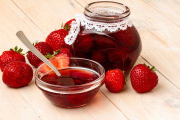 Strawberry jam in a jar on wooden background