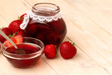 Strawberry jam in a jar on wooden background