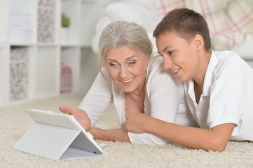 Portrait of girl with grandmother using tablet