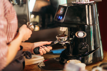 Barista using a coffee machine in cafe