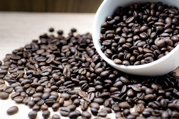 Coffee beans are placed in containers and spread on the background of wood grain.