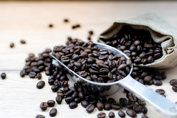 Coffee beans are placed in containers and spread on the background of wood grain.
