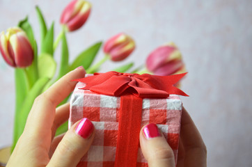 Women's day. Pink tulips bouquet and a gift on white background, banner, top view, space for text