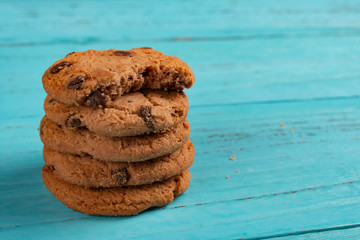 stack of sweet cookies on blue background and the top one with a bite