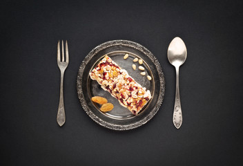 Metal antique plate, spoon and fork, on a black background