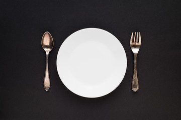 Vintage silver plate, spoon and fork on black background