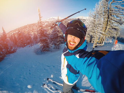 Selfie Guy sportsman goes on normal skiing on ski slope with action camera. Sunset. winter