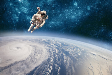 Astronaut in outer space against the backdrop of the planet earth. Typhoon over planet Earth.