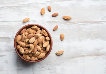 Almonds in a bowl on the wood table,top view