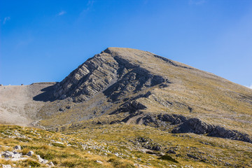 Lonely mountain peak top on clear blue sky background wallpaper pattern 