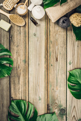 flat lay layout with monstera leaves and cosmetic care products