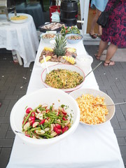 A buffet table with an assortment of different salads, with party decor, Pasta salad, potato salad, bean salad and fresh mixed salad.
