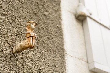 Top of a wooden shutter with a woman's head