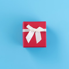 Red gift box with white ribbon bow, concept of giving present and Valentine's, anniversary, mother's day and birthday surprise, copy space, top view