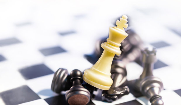 business winner concept, the white king chess stand on top of the black cheses on game board