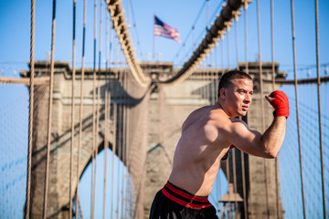 Young athlete fighter exercising on Brooklyn bridge in New York City