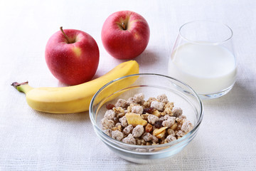 Healthy food with Corn Flakes cereal in a bowl, apple, banana and glass with milk. Morning breakfast.
