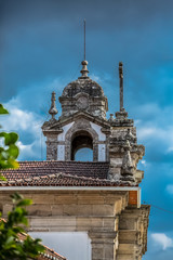 View of a church tower and roof, dramatic sky on background