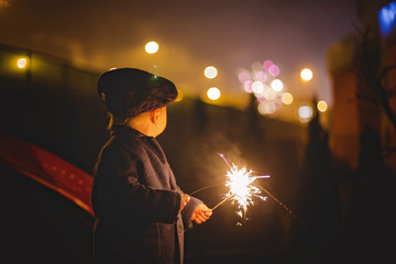 Waist up portrait of happy family celebrating New Year together and lighting sparklers outdoors