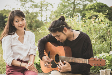 asian younger man and woman playing guitar with happiness emotion