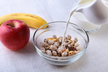 Healthy food with Corn Flakes cereal in a bowl, apple, banana and glass with milk. Morning breakfast.